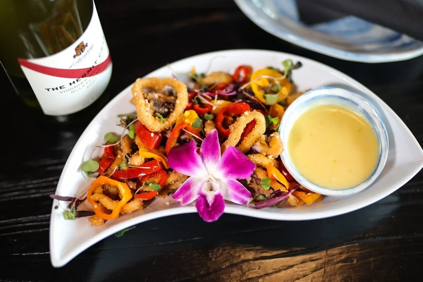 High Tide Social House signature dishes Figs in Pear-Adise Pizza, Calamari, Baked Goat Cheese.