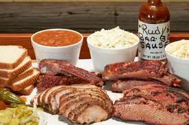 Rudy’s “Country Store” and Bar-B-Q signature dishes Moist Brisket, Sausage, Creamed Corn, Baby Back Ribs.